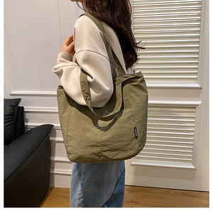 Détail d'un grand sac cabas en nylon vert herbe avec texture plissée et étiquette