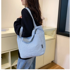 Detail of light blue nylon tote bag with fashion tag and crinkled texture fabric