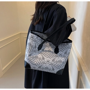 Detail of printed tote bag with ocean wave patterns and black leather corner guards