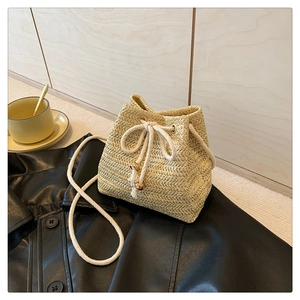 Macro detail of hand-woven straw bucket bag texture with drawstring and wood beads