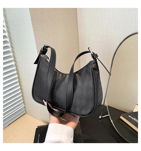 Detailed view of black crescent bag featuring quilted faux leather and metal zipper