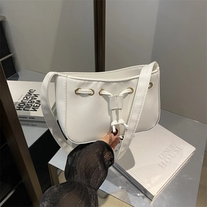Minimalist white faux leather shoulder bag with drawstring detail and gold eyelets