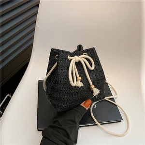 Handwoven black bucket bag with cream drawstring, gold beads and tassel detailing
