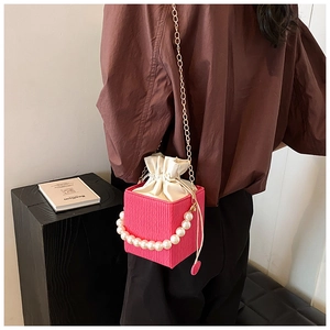 Detail of rose pink cubic crossbody bag with pearl handle and drawstring inner lining