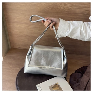 Close-up of silver chain strap and metallic pleated texture on the stylish tote bag