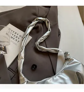 Détail de la poignée plissée et de la finition argentée de ce sac à bandoulière