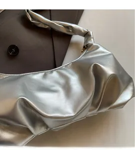 Détail du sac nuage argenté métallisé avec bandoulière torsadée et texture plissée chic