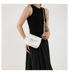 Detail of white striped crossbody bag with colorful vertical lines and gold metal chain