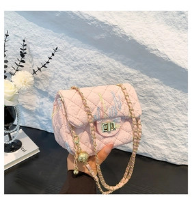 Close-up of pink quilted crossbody bag with embroidery, gold chain and orb pendant