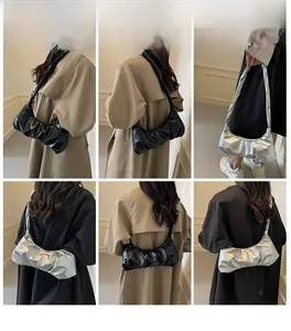 Vues détaillées du sac nuage froncé en noir et argent porté par un mannequin en trench