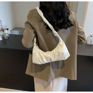 Détail du sac nuage blanc plissé avec bandoulière nouée sur l'épaule du mannequin