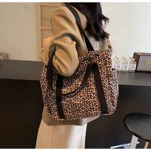 Detailed side view of leopard print tote bag with multi-pocket and shoulder strap