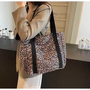 Detail of high-capacity leopard print tote bag with reinforced black strap for daily commute