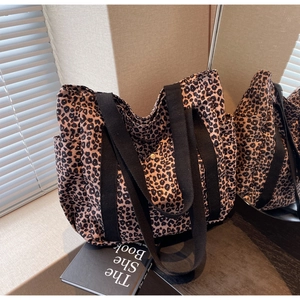 Detailed side view of leopard print tote bag featuring a functional open side pocket