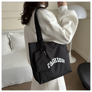 Détail du sac cabas en toile noire avec imprimé FASHION et petite pochette assortie