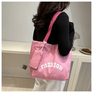 Détail d'un sac cabas rose avec lettrage FASHION et une petite pochette zippée assortie