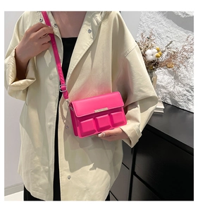 Detail of fuchsia crossbody bag with unique 3D chocolate square texture and gold trim