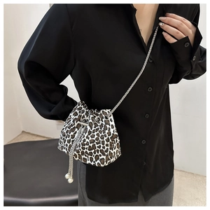 Detailed view of leopard print bucket bag with drawstring closure and silver chain strap