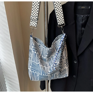 Detail of blue and white geometric plaid canvas tote with patterned wide strap