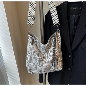 Detail of grey geometric jacquard canvas tote bag with woven strap on suit jacket