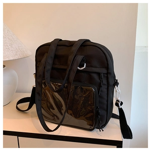 Dettaglio borsa tote in nylon nero con tasca in PVC e fibbie bianche a contrasto