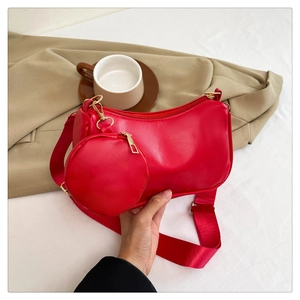 Detail of red glossy shoulder bag with matching coin purse and golden metallic zipper