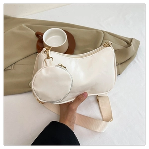 White PU leather half-moon bag with matching coin purse and wide fabric strap in hand
