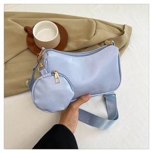 Detail of light blue baguette bag with gold hardware and small round coin purse charm
