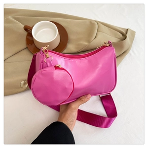 Detail of rose pink faux leather shoulder bag with matching round coin purse and woven strap