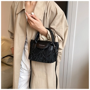 Detail of black quilted nylon crossbody bag with fashion embroidery and elegant handle