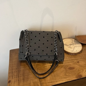 Sac fourre-tout chic en toile grise avec pois noirs et broderie papillon sur table