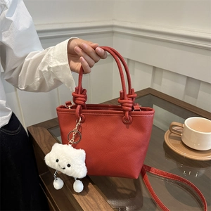Borsa a secchiello rossa con texture litchi, manico annodato e ciondolo a nuvola
