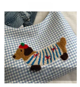 Close-up of blue plaid tote bag featuring a cute dachshund towel embroidery detail