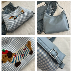Detail view of checkered light blue tote bag with dachshund embroidery and metal buckle