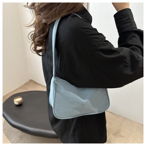 French minimalist light blue shoulder bag with natural pleated texture on female model