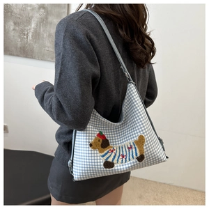 Detail of blue plaid fabric tote featuring cute cartoon dachshund dog embroidery