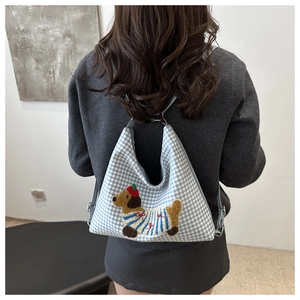 Detail of blue plaid tote bag featuring a cute dachshund embroidery patch on fabric