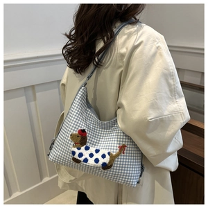 Detail of blue and white checkered tote bag with a cartoon dachshund embroidery