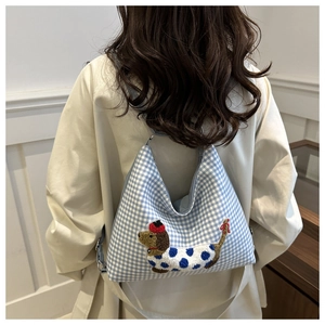 Detail of blue and white checkered tote bag with 3D dachshund dog embroidery on fabric