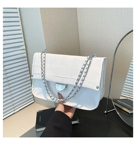 Close-up of white pleated nylon shoulder bag with silver chain strap and metal buckle