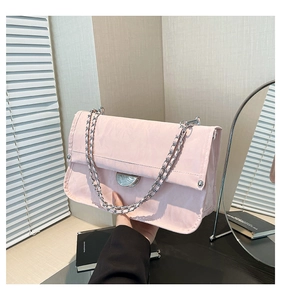 Detail of light pink shoulder bag with pleated texture and silver chain strap