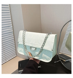 Detail of mint green textured flap bag with silver chain strap and metal clasp