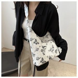Detail of artistic butterfly print on white canvas tote bag with adjustable strap