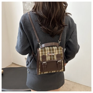 Détail d'un mini sac à dos à carreaux avec broderie et lanières en similicuir