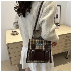 Détail du sac à dos à carreaux avec broderie chien et lanières en cuir en intérieur