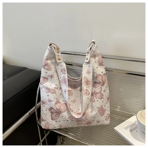 Detail of white butterfly print tote bag with wide strap and gold metal rings