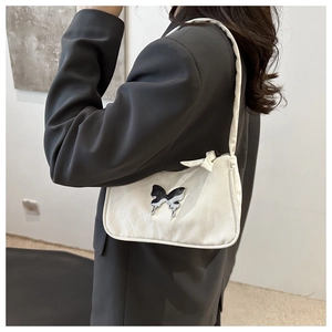 Détails de texture du sac blanc plissé avec décoration papillon en métal élégante