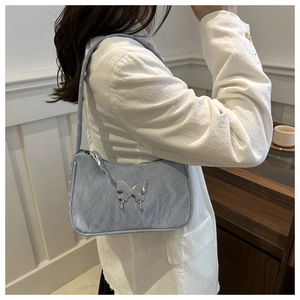 Détail du sac sous l'aisselle bleu clair avec boucle papillon fluide et texture plissée
