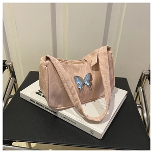 Détail du sac hobo plissé rose clair avec une boucle décorative en papillon argenté