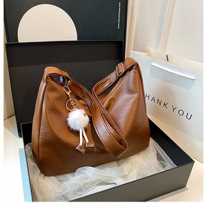 Brown soft PU leather hobo shoulder bag with plush doll charm in a luxury gift box